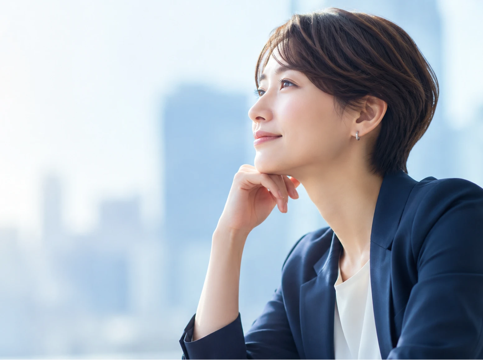都会のオフィスで窓の外を見つめる女性